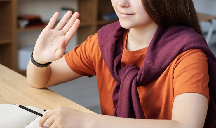 Étudiante qui salue pendant un cours en ligne