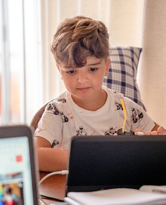 Jeune apprenant devant sa tablette