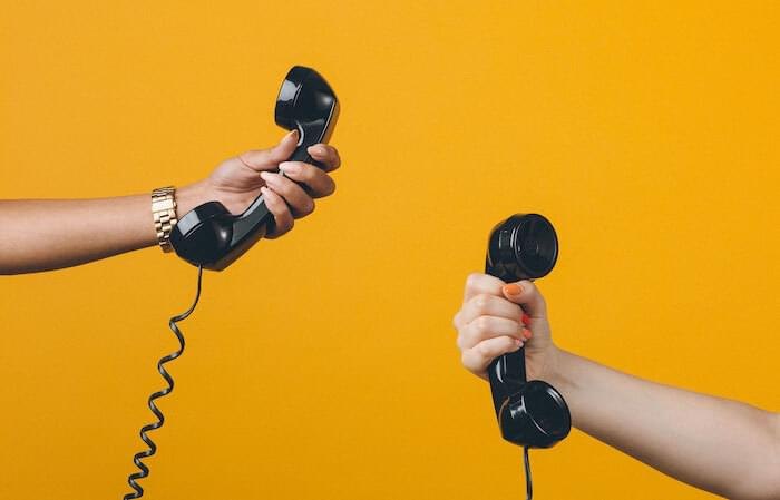 Deux mains tenant des combinés téléphoniques